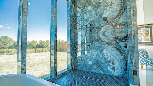 bathroom with a freestanding tub and a marble finish shower