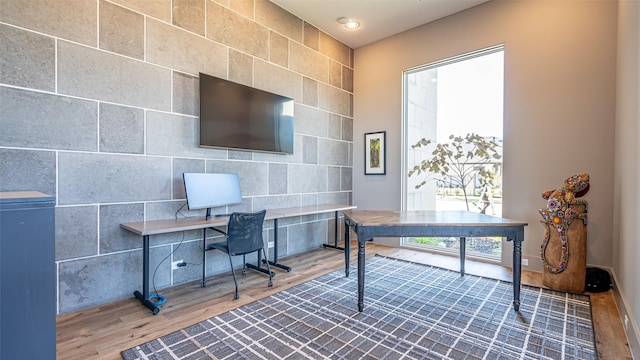 home office with built in desk and wood finished floors