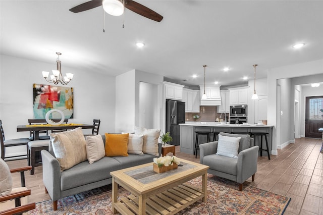 living room featuring baseboards, light wood-style flooring, and recessed lighting