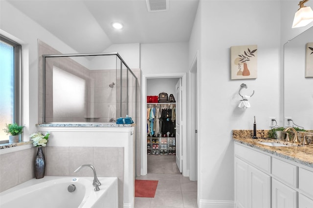 bathroom featuring a garden tub, tile patterned flooring, vanity, a spacious closet, and a shower stall