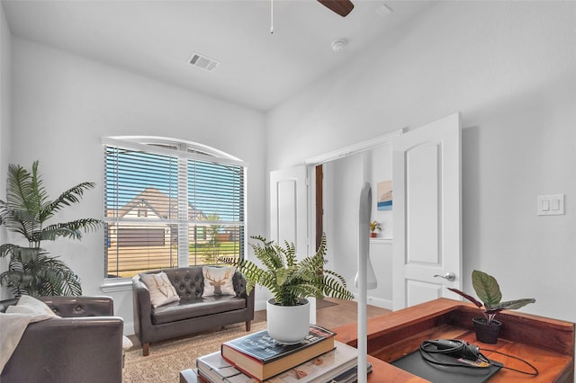 living room featuring ceiling fan, visible vents, and baseboards