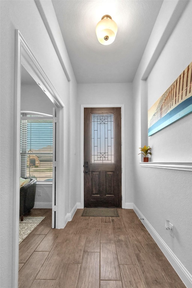 entrance foyer featuring wood tiled floor and baseboards