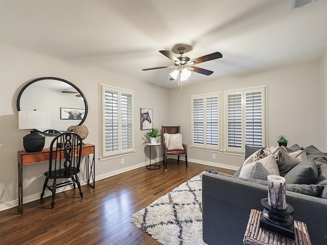 living area with ceiling fan, visible vents, baseboards, and wood finished floors