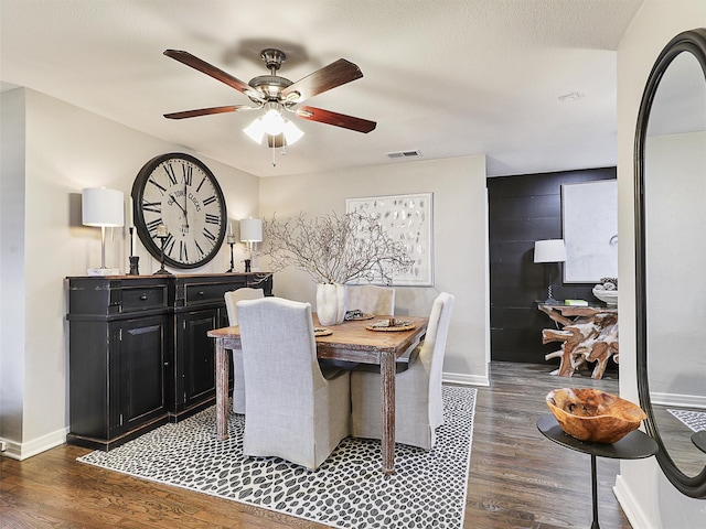 dining space featuring visible vents, baseboards, ceiling fan, and wood finished floors