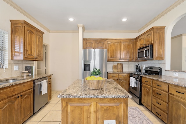 kitchen with light stone countertops, stainless steel appliances, a sink, and light tile patterned flooring