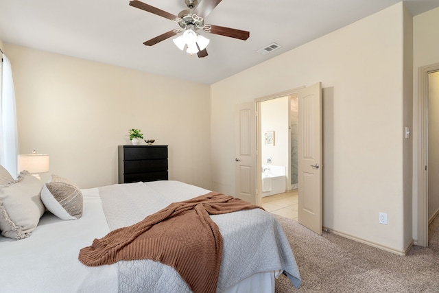 bedroom with light colored carpet, a ceiling fan, baseboards, visible vents, and ensuite bath