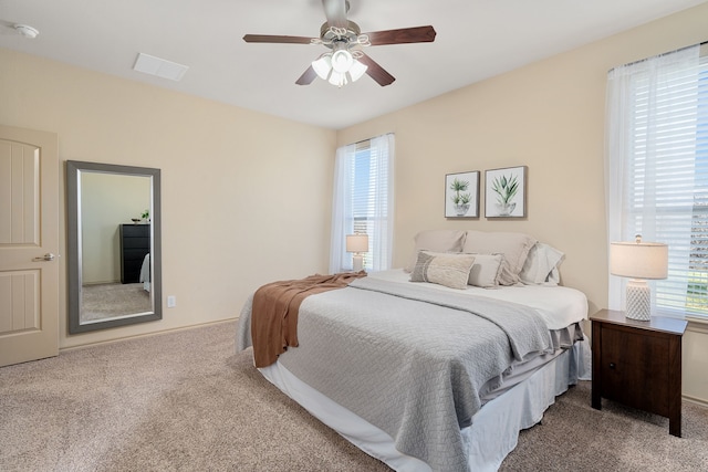 carpeted bedroom with ceiling fan and visible vents