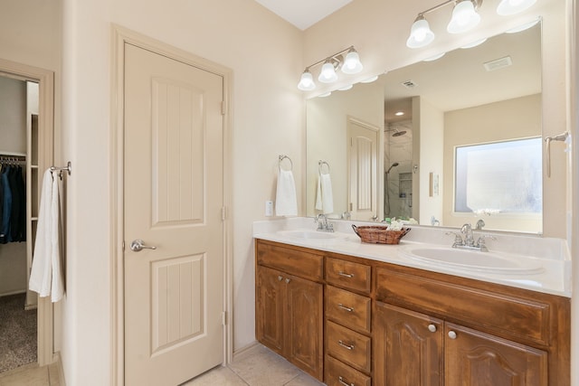 bathroom with tile patterned flooring, visible vents, a sink, and tiled shower