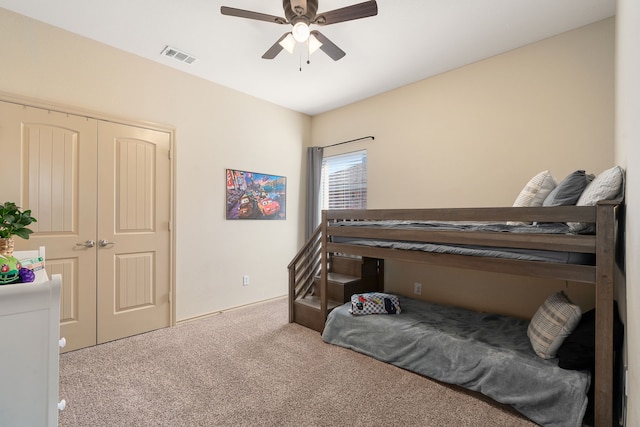 bedroom with a closet, carpet, visible vents, and a ceiling fan