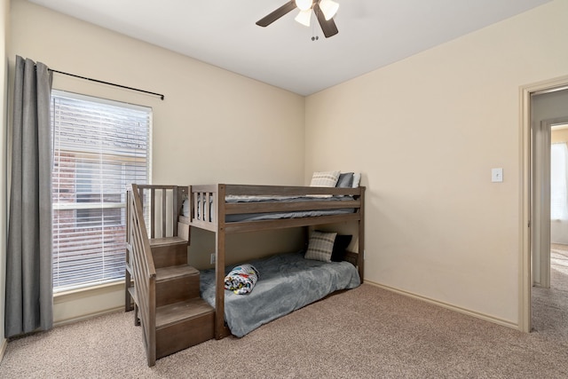 carpeted bedroom with a ceiling fan and baseboards