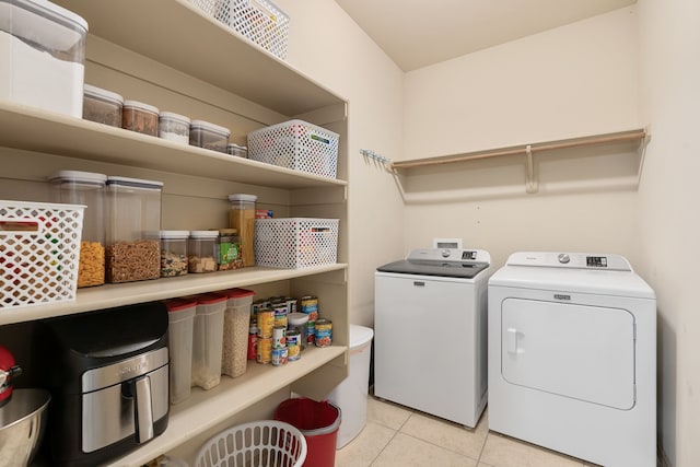 washroom featuring light tile patterned floors, laundry area, and independent washer and dryer