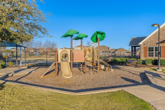 community playground featuring fence and a residential view