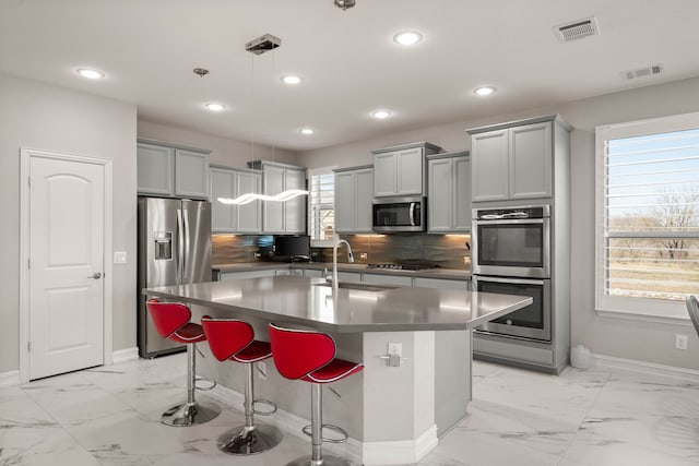 kitchen with a sink, visible vents, marble finish floor, and appliances with stainless steel finishes