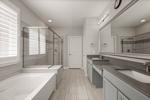 full bath featuring a sink, a stall shower, and double vanity