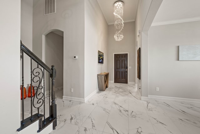 foyer entrance featuring visible vents, marble finish floor, arched walkways, an inviting chandelier, and baseboards