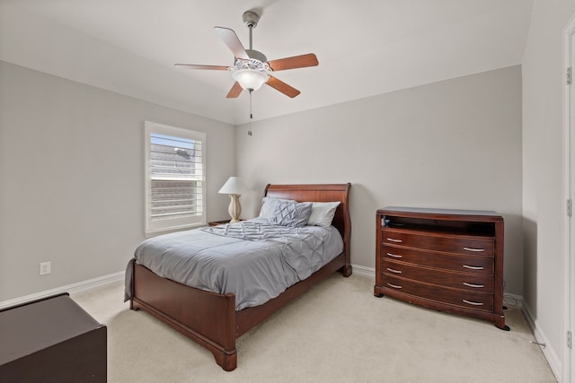 bedroom featuring light carpet, ceiling fan, and baseboards