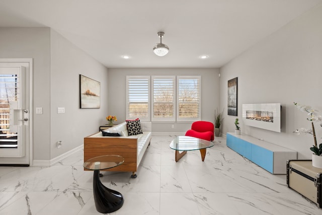 sitting room featuring a glass covered fireplace, recessed lighting, baseboards, and marble finish floor