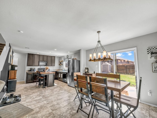 dining area with baseboards, recessed lighting, and an inviting chandelier