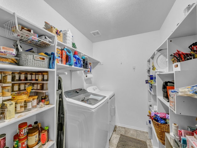 laundry room with laundry area, baseboards, visible vents, a textured ceiling, and washer and dryer