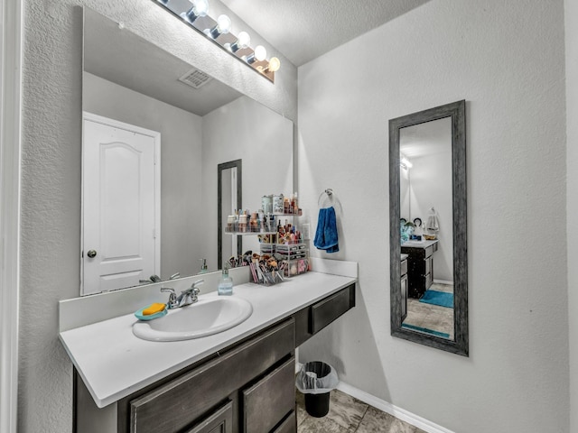 bathroom featuring baseboards, visible vents, and vanity