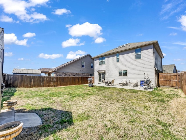 back of house featuring a lawn, a patio area, and a fenced backyard