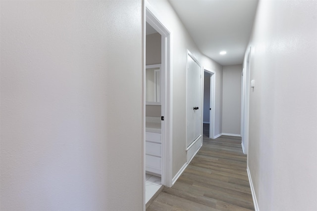 hall with baseboards and light wood-style floors