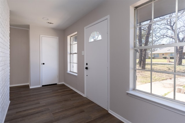 foyer featuring dark wood finished floors, visible vents, and baseboards