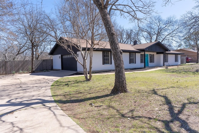 view of front of home with driveway, a chimney, a front lawn, and fence