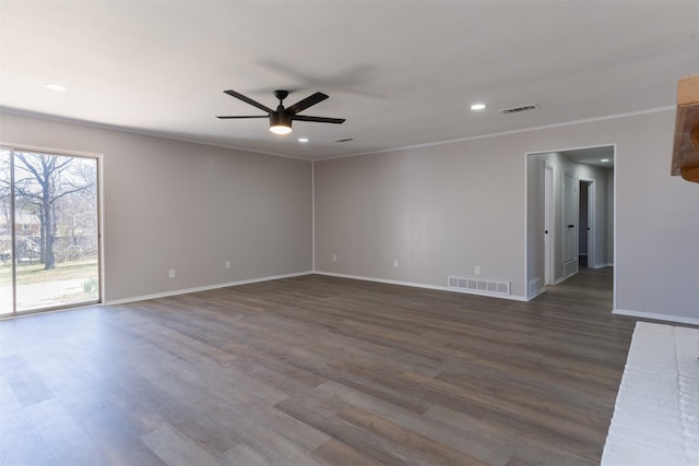 empty room featuring visible vents, crown molding, dark wood-type flooring, and a ceiling fan