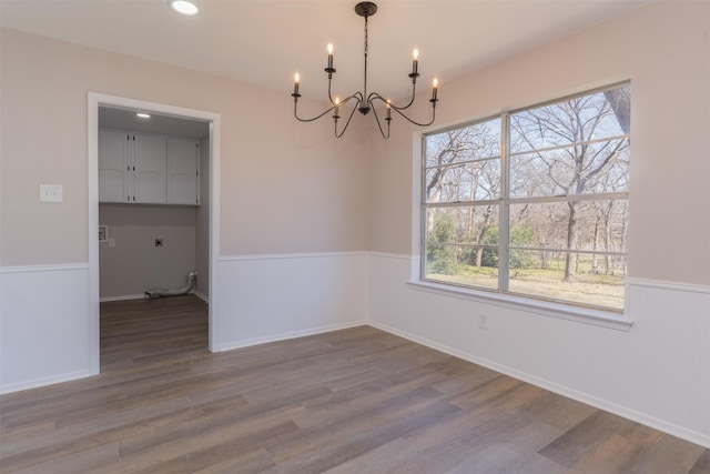 unfurnished dining area with a notable chandelier, recessed lighting, baseboards, and wood finished floors