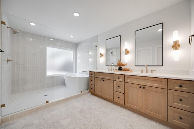 bathroom with a freestanding tub, double vanity, a sink, and walk in shower