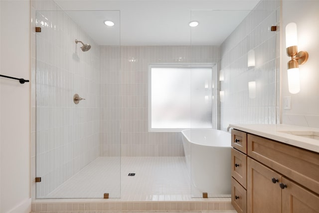 full bathroom featuring recessed lighting, a tile shower, and vanity