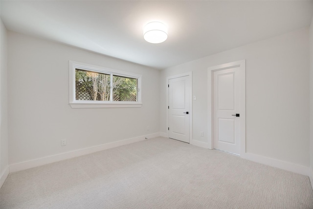 unfurnished bedroom featuring baseboards and light colored carpet