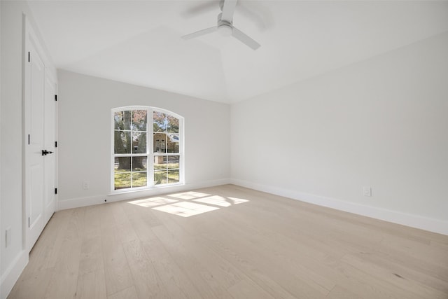 unfurnished room featuring light wood-style flooring, baseboards, vaulted ceiling, and a ceiling fan