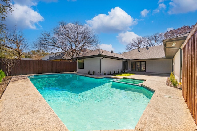 view of swimming pool featuring a patio area, a fenced backyard, and a pool with connected hot tub