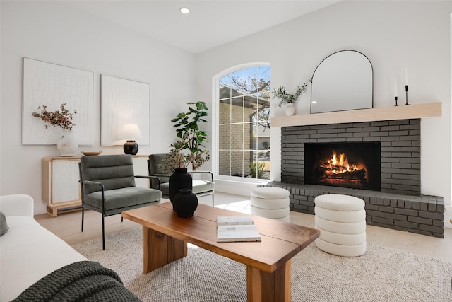 living room with light wood-type flooring, a brick fireplace, and recessed lighting