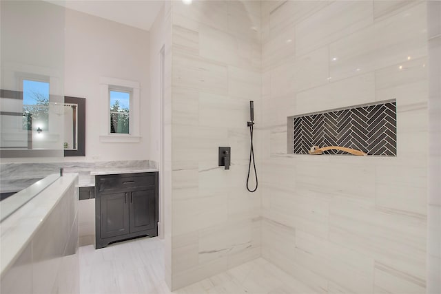 bathroom featuring tiled shower and vanity