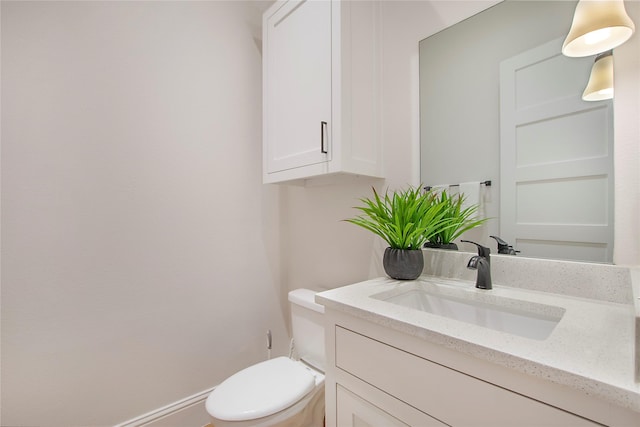 half bathroom with vanity and toilet