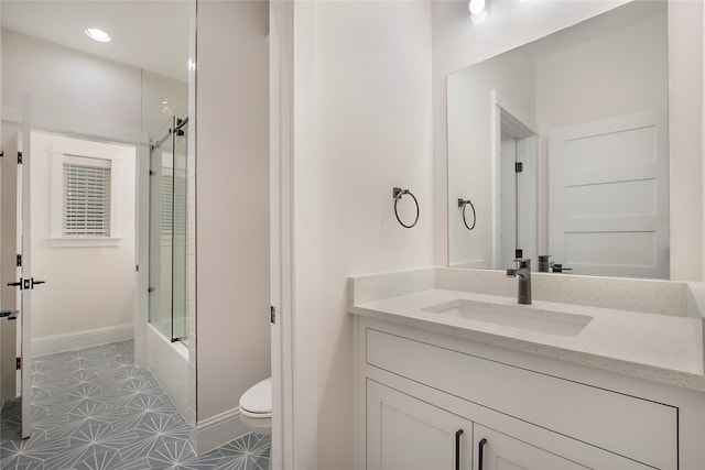 bathroom with toilet, vanity, tile patterned floors, bath / shower combo with glass door, and baseboards