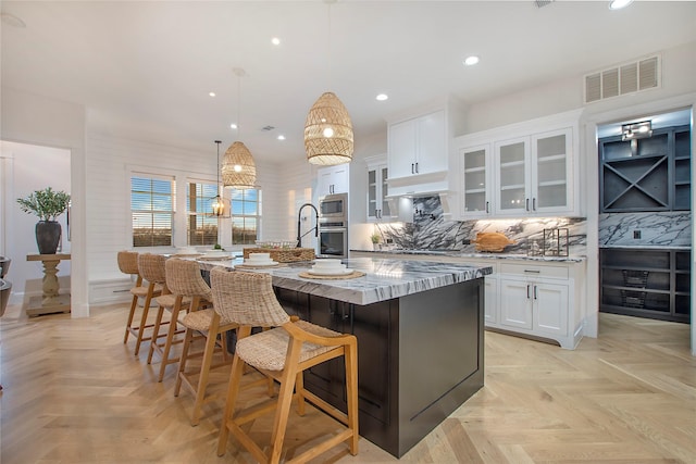 kitchen featuring recessed lighting, a spacious island, visible vents, stainless steel appliances, and white cabinets