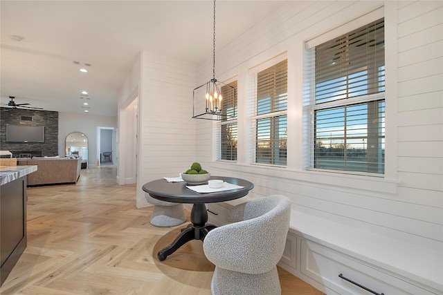 dining area featuring wood walls, ceiling fan with notable chandelier, and recessed lighting