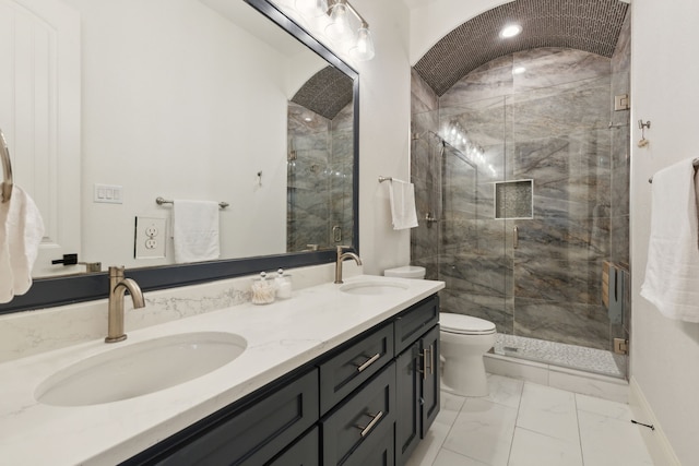 full bathroom featuring double vanity, marble finish floor, toilet, and a sink