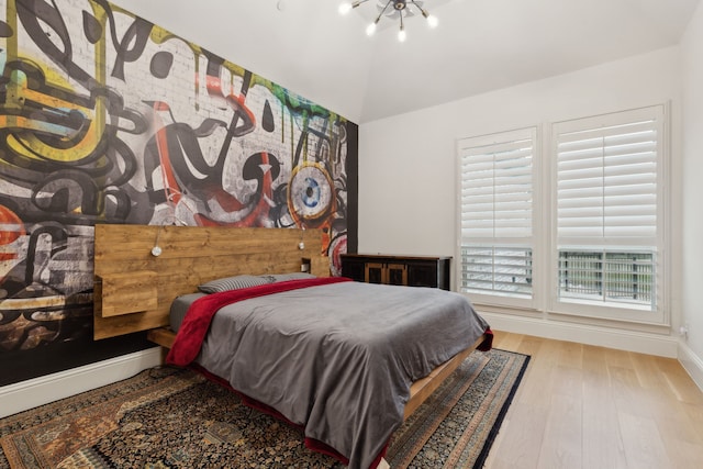 bedroom featuring wood finished floors, baseboards, and a chandelier