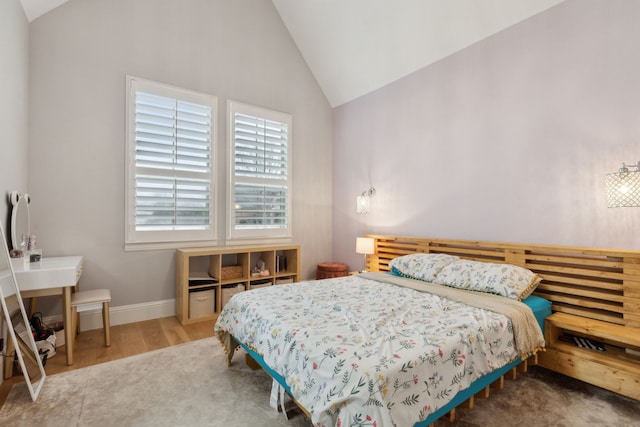 bedroom featuring wood finished floors, baseboards, and vaulted ceiling