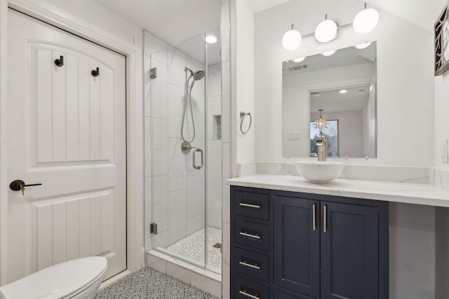 full bathroom featuring vanity, a shower stall, toilet, and visible vents