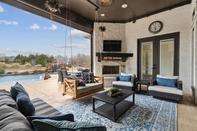 view of patio / terrace with an outdoor living space with a fireplace and an outdoor pool