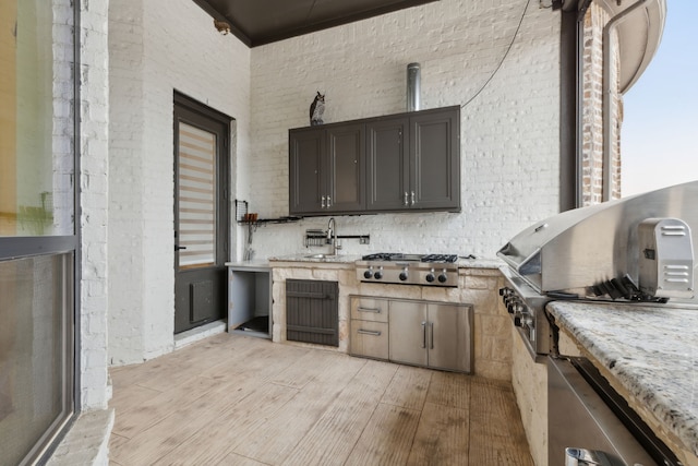 view of patio / terrace featuring a sink, exterior kitchen, and a grill