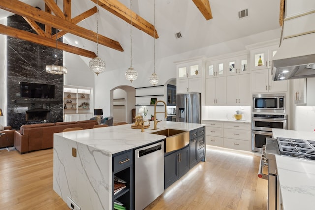 kitchen featuring visible vents, arched walkways, appliances with stainless steel finishes, and a sink