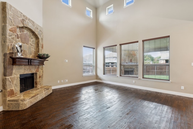 unfurnished living room featuring plenty of natural light, a fireplace, and dark wood finished floors