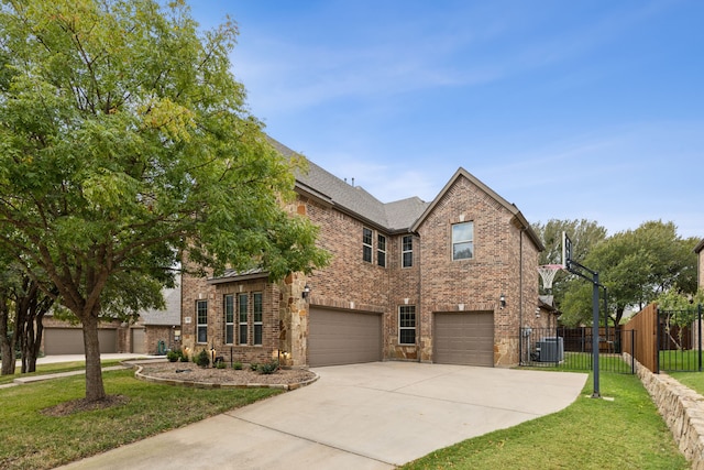 traditional-style home with a garage, central AC unit, fence, a front lawn, and brick siding